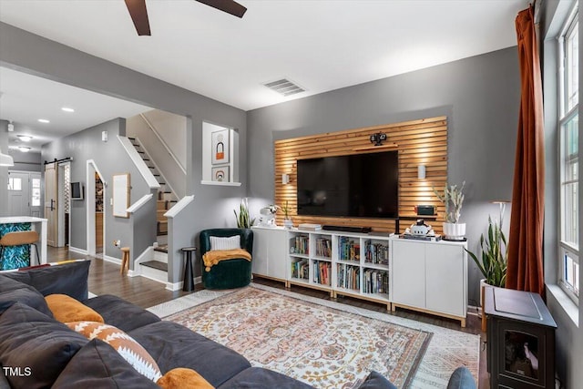 living room with ceiling fan, a barn door, and hardwood / wood-style floors