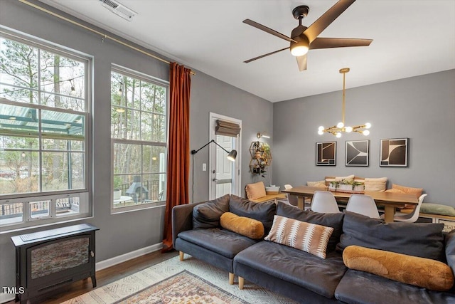 living room featuring hardwood / wood-style floors and ceiling fan with notable chandelier