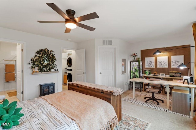 carpeted bedroom with ceiling fan and stacked washer and dryer