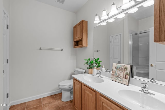bathroom featuring tile patterned flooring, vanity, toilet, and walk in shower