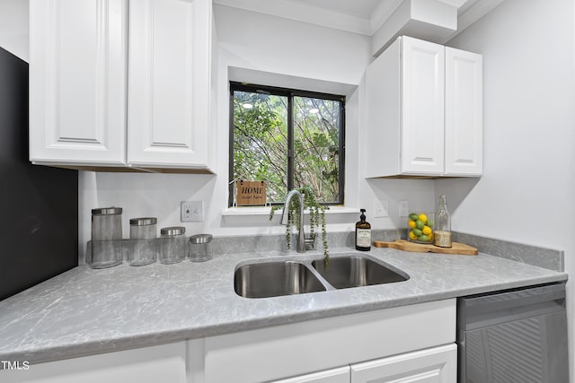 kitchen with light stone counters, crown molding, stainless steel dishwasher, white cabinetry, and a sink