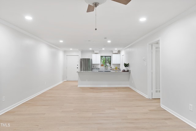 unfurnished living room featuring ornamental molding, light wood-type flooring, and baseboards