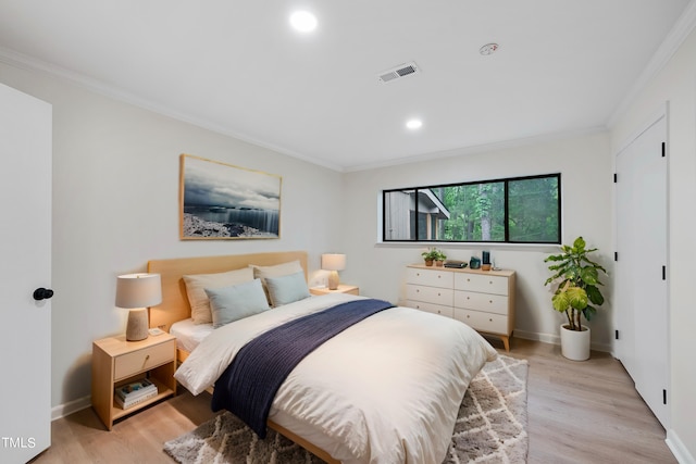 bedroom with visible vents, crown molding, light wood-style flooring, and baseboards