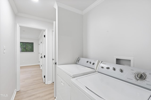 washroom featuring light wood-type flooring, washing machine and dryer, and crown molding