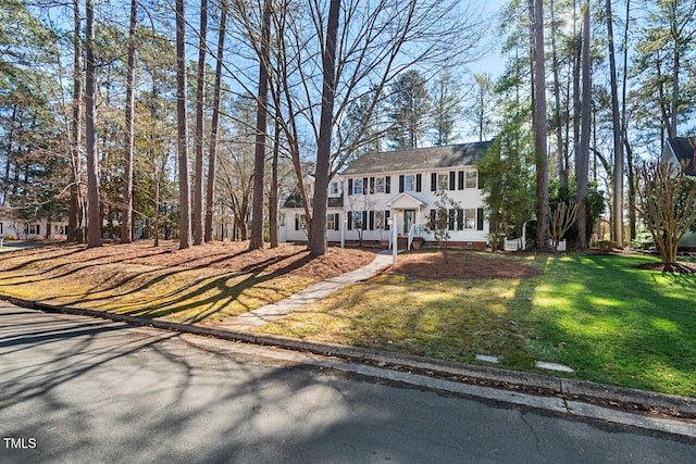 colonial inspired home featuring a front lawn