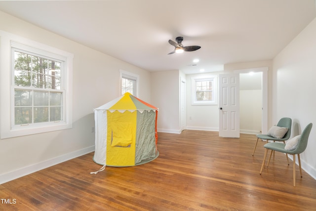 game room with hardwood / wood-style flooring, a healthy amount of sunlight, and ceiling fan