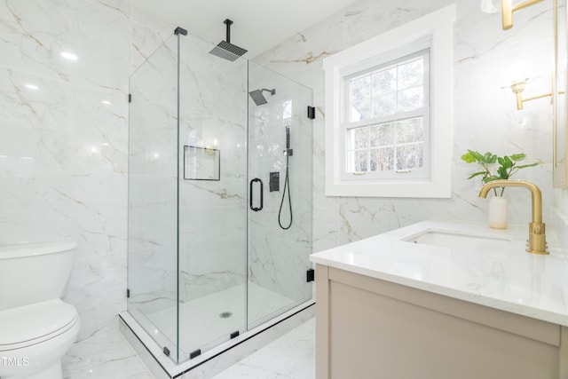 bathroom featuring vanity, toilet, a shower with shower door, and tile walls