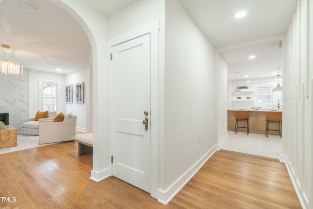 hallway with sink and light wood-type flooring