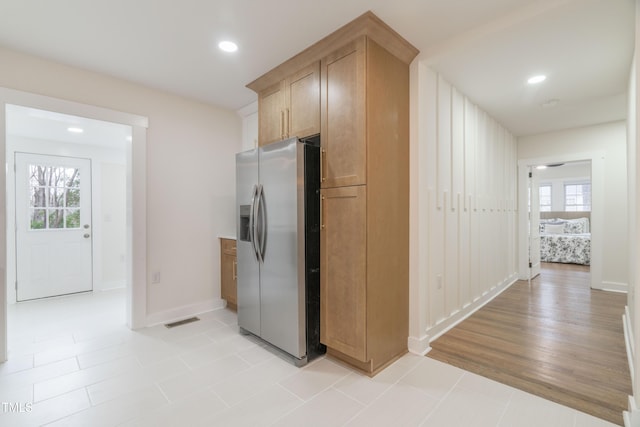 kitchen featuring stainless steel refrigerator with ice dispenser and light tile patterned flooring