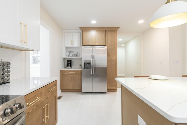 kitchen with light stone counters, decorative backsplash, stainless steel appliances, and white cabinets