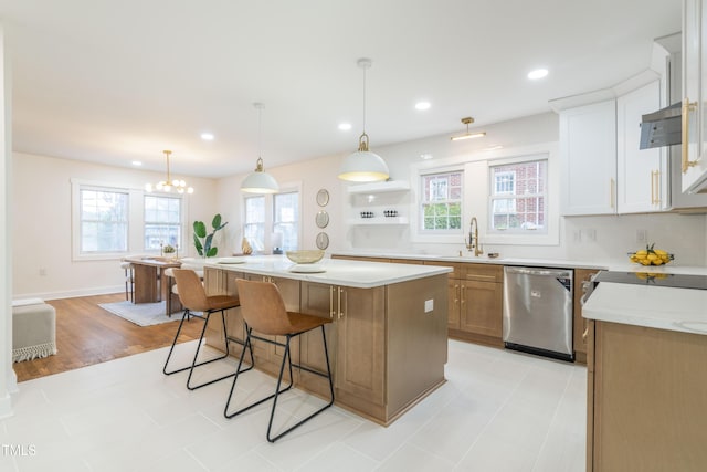 kitchen with a kitchen island, dishwasher, sink, white cabinets, and hanging light fixtures