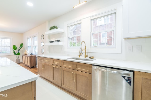 kitchen with sink, decorative backsplash, light stone countertops, and dishwasher