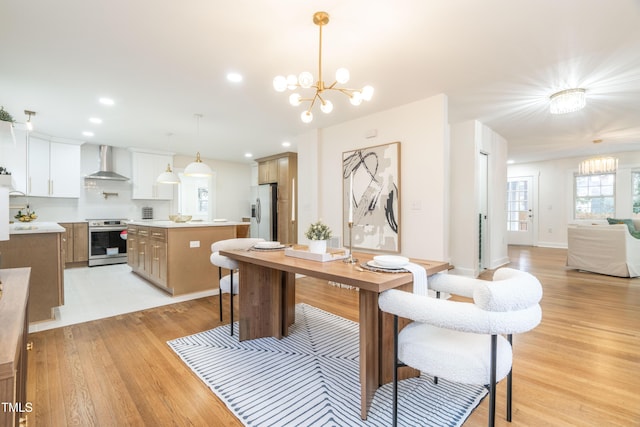 dining room with light wood-type flooring and a notable chandelier