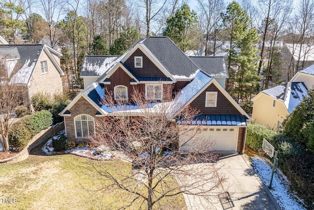 craftsman inspired home with driveway, a garage, metal roof, a standing seam roof, and a front yard