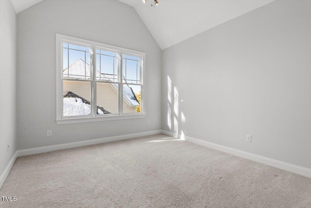 carpeted empty room with lofted ceiling and baseboards