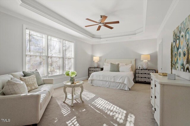 bedroom featuring baseboards, a raised ceiling, crown molding, and light colored carpet