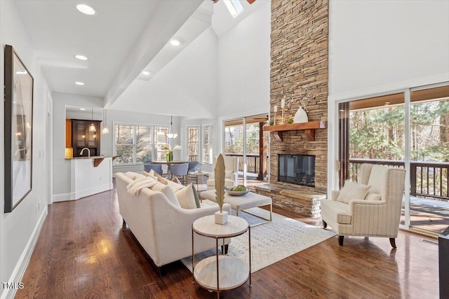 living room featuring recessed lighting, dark wood-style flooring, a fireplace, a towering ceiling, and baseboards