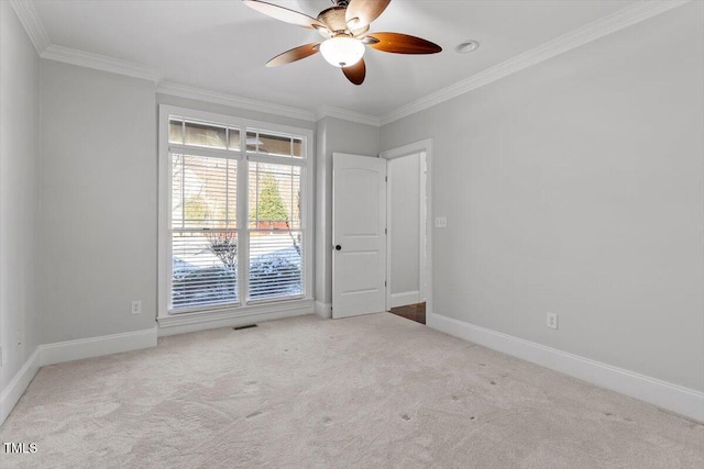 unfurnished room featuring baseboards, ornamental molding, visible vents, and light colored carpet