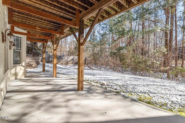 snow covered patio featuring fence