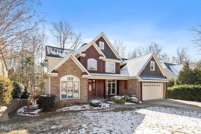 craftsman house with driveway, stone siding, metal roof, a standing seam roof, and board and batten siding