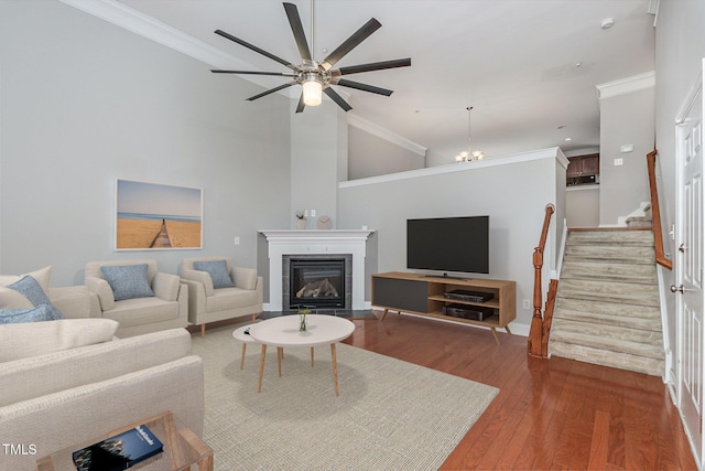 living room with crown molding, high vaulted ceiling, hardwood / wood-style floors, and a notable chandelier