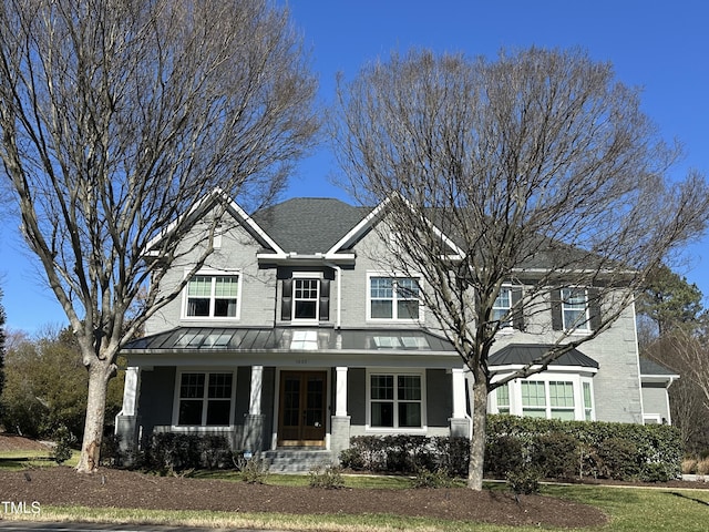 craftsman-style house with a standing seam roof, brick siding, metal roof, and covered porch