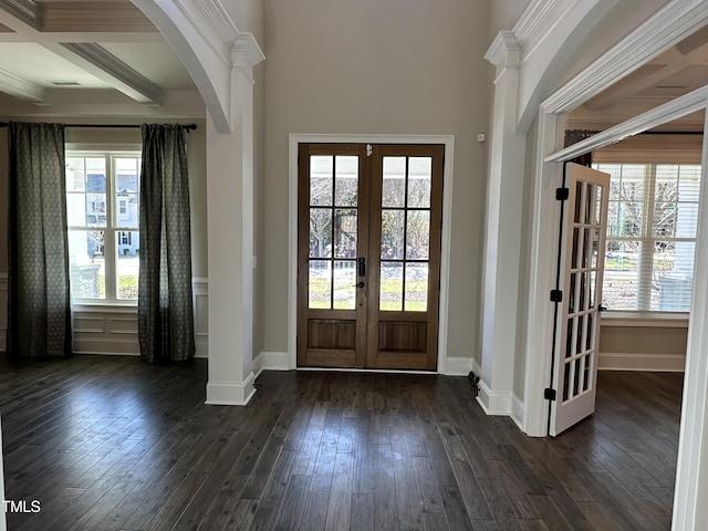 foyer entrance featuring arched walkways, dark wood-style flooring, baseboards, french doors, and beamed ceiling