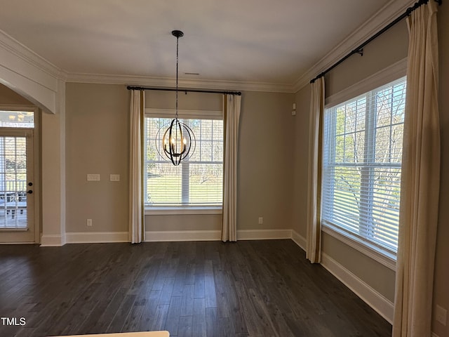 unfurnished dining area with dark wood-style floors, arched walkways, a wealth of natural light, and crown molding