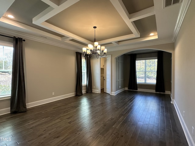 spare room featuring baseboards, visible vents, arched walkways, and dark wood-type flooring