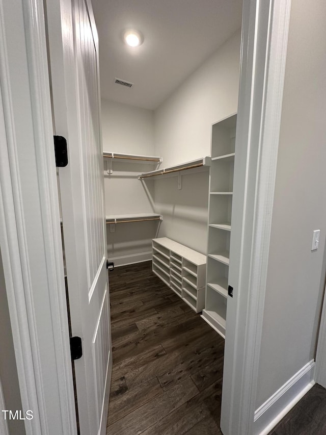 spacious closet featuring dark wood-type flooring and visible vents