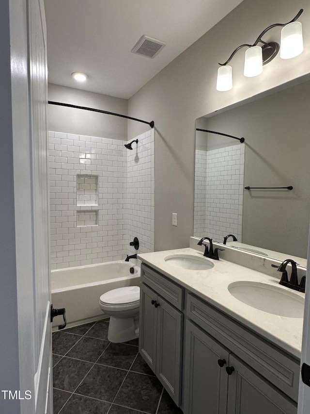 bathroom with double vanity, visible vents, a sink, and tile patterned floors