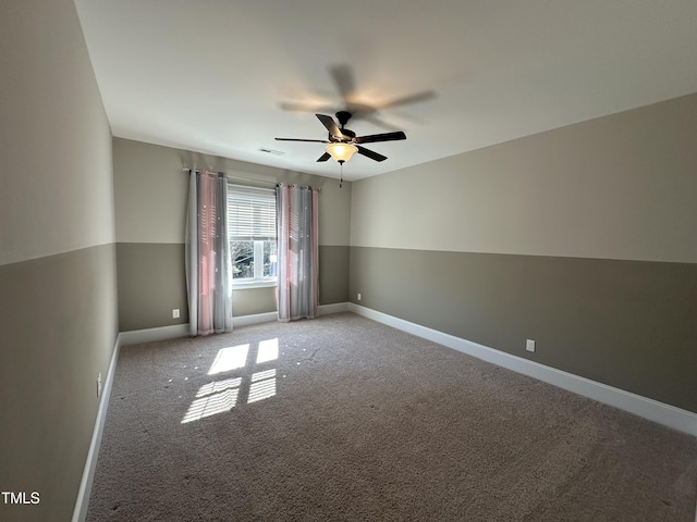 spare room with ceiling fan, carpet, visible vents, and baseboards