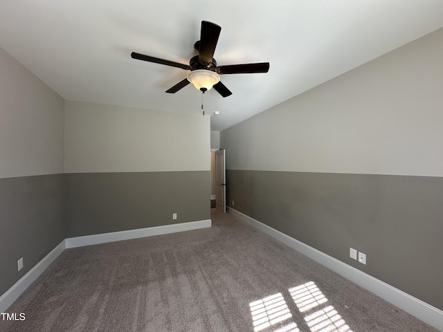 carpeted empty room with a ceiling fan and baseboards