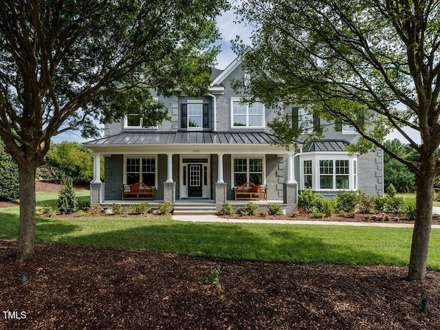 craftsman inspired home featuring metal roof, a front lawn, and a standing seam roof