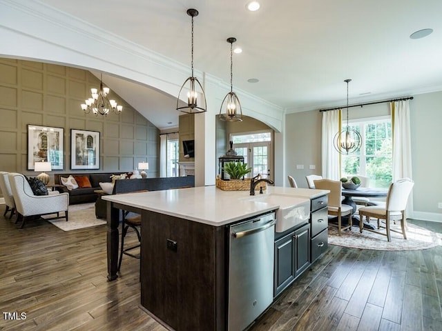 kitchen with a kitchen island with sink, open floor plan, light countertops, dishwasher, and an inviting chandelier