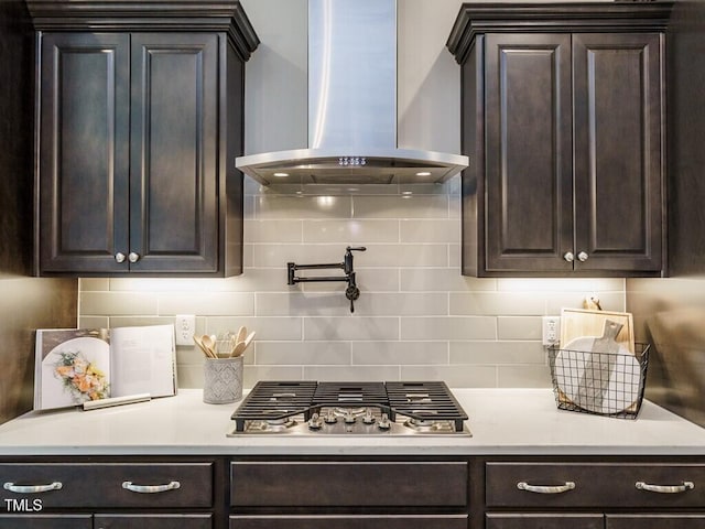 kitchen with decorative backsplash, light countertops, stainless steel gas cooktop, and ventilation hood