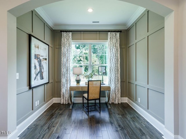 home office with crown molding, dark wood-style flooring, arched walkways, and a decorative wall