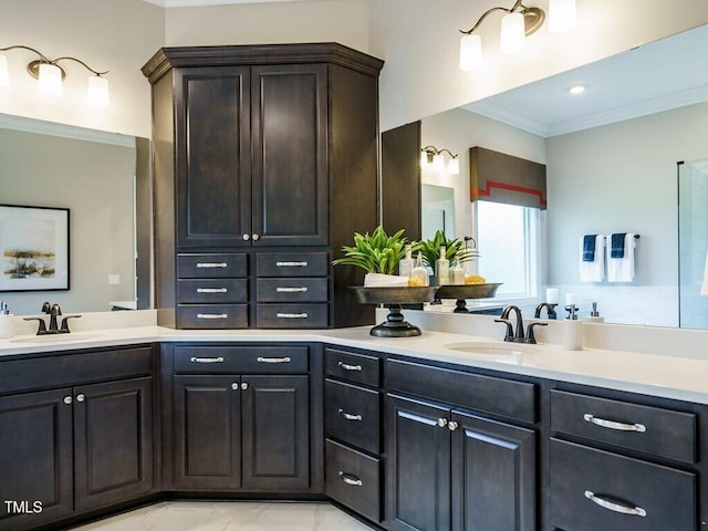 full bath with double vanity, marble finish floor, ornamental molding, and a sink