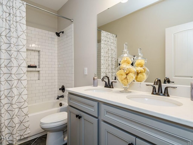 bathroom featuring double vanity, shower / tub combo, toilet, and a sink