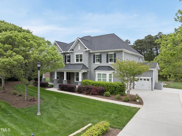 view of front of house featuring roof with shingles, a front lawn, driveway, covered porch, and an attached garage