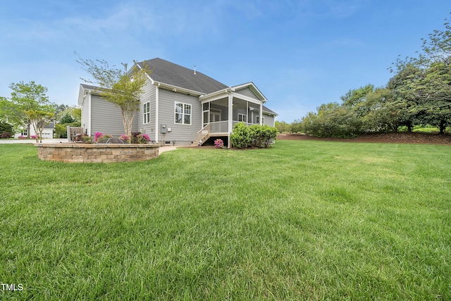 back of house featuring a lawn and a sunroom