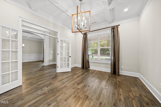 unfurnished dining area with arched walkways, crown molding, a notable chandelier, and french doors