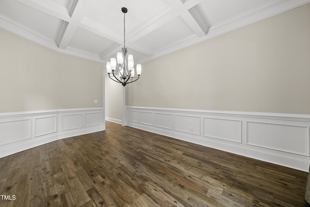 unfurnished dining area featuring a chandelier, a wainscoted wall, beamed ceiling, coffered ceiling, and dark wood-type flooring