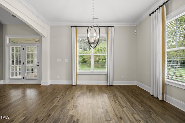 unfurnished dining area with plenty of natural light, dark wood-style flooring, ornamental molding, and a notable chandelier