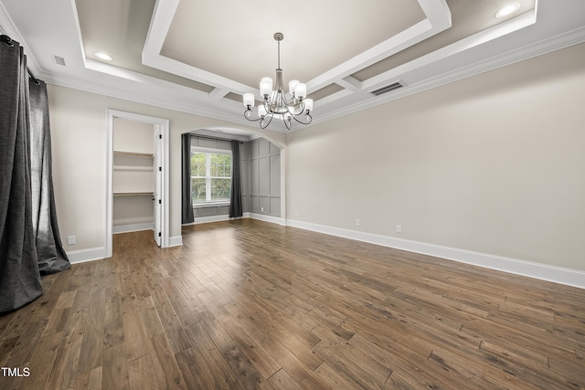 unfurnished dining area with dark wood finished floors, visible vents, arched walkways, crown molding, and a notable chandelier