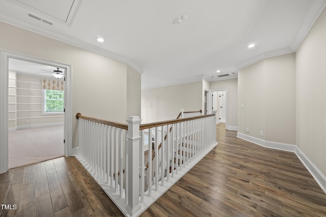 corridor with hardwood / wood-style floors, visible vents, baseboards, and an upstairs landing
