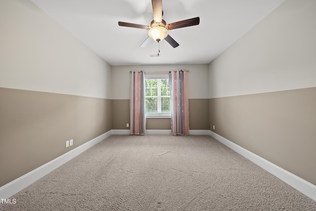 carpeted empty room with baseboards and a ceiling fan