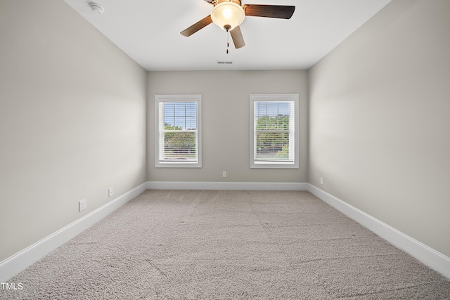 empty room with light carpet, a ceiling fan, and baseboards