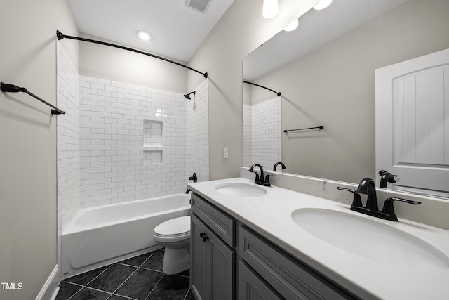 full bathroom with shower / bathing tub combination, tile patterned floors, toilet, and a sink