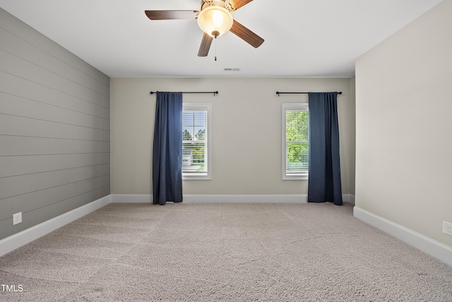 spare room featuring baseboards, a ceiling fan, carpet flooring, and visible vents